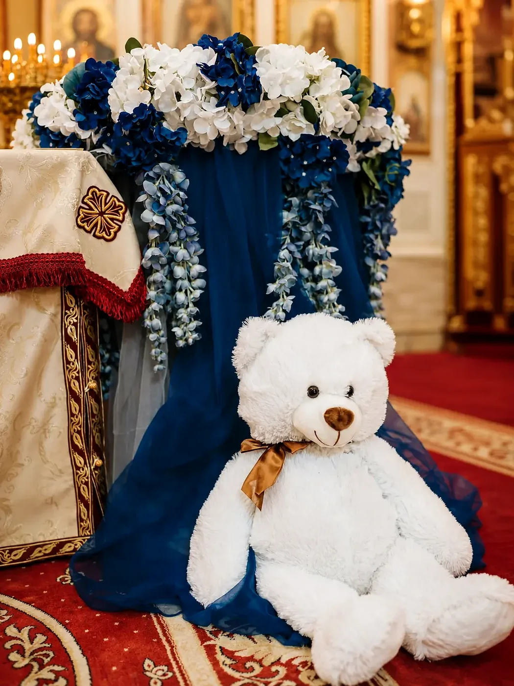 Blåt blomsterarrangement med bamse til barnedåb